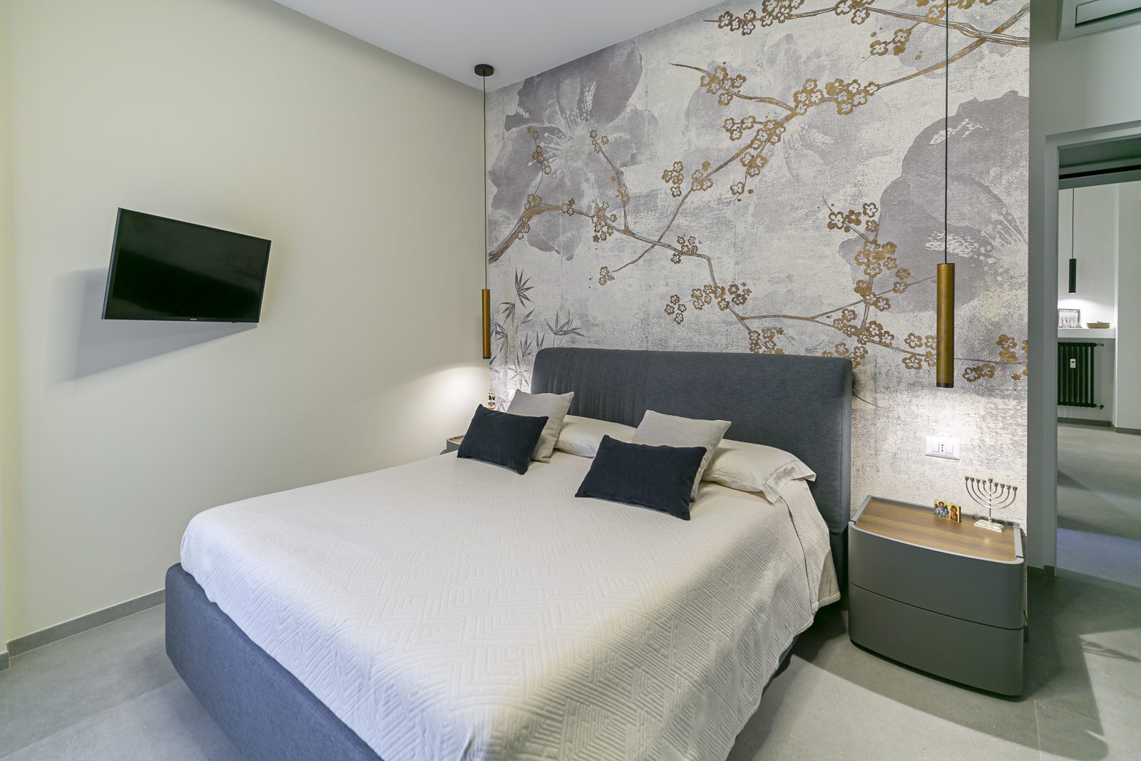 Camera da letto con testata in carta da parati floreale e luce progettata